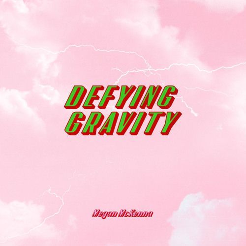 A pink background with green and red text that says defying gravity.