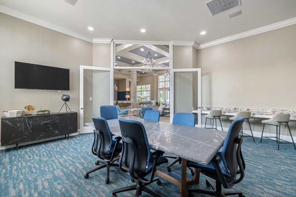 a conference room with a large table and chairs and a flat screen tv at The Preserve at Ballantyne Commons in Charlotte, NC.