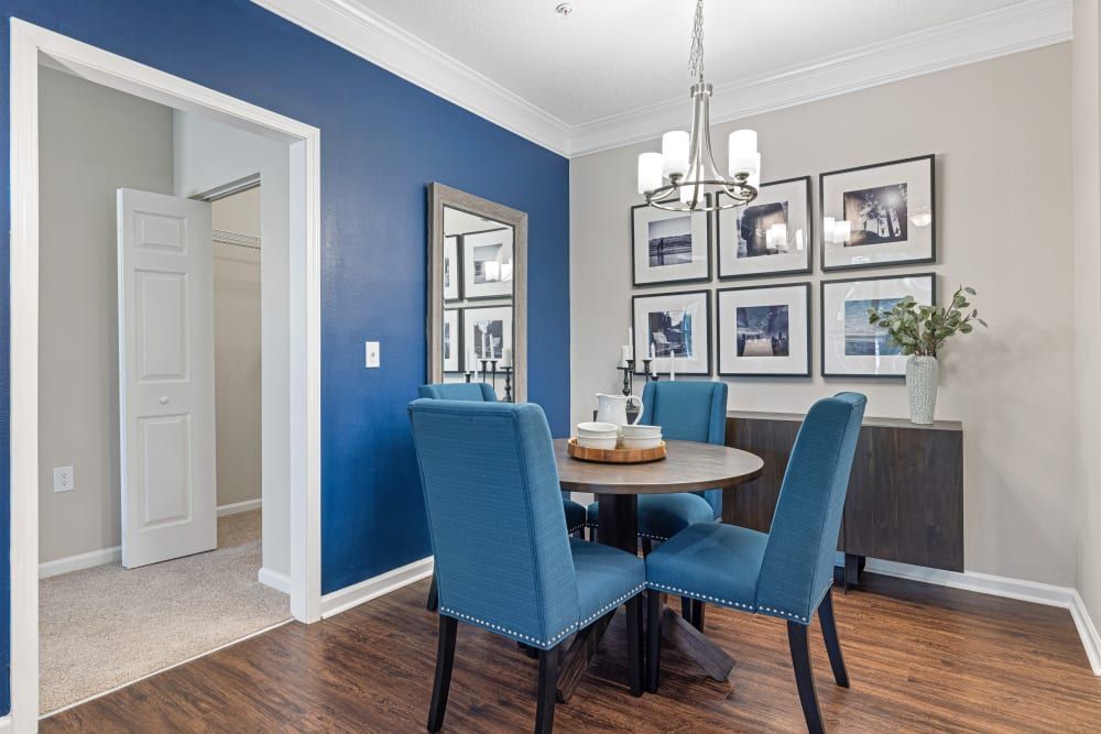 a dining room with blue chairs , a table and a chandelier at The Preserve at Ballantyne Commons in Charlotte, NC.