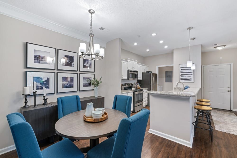a dining room with a round table and blue chairs in a house at The Preserve at Ballantyne Commons in Charlotte, NC.
