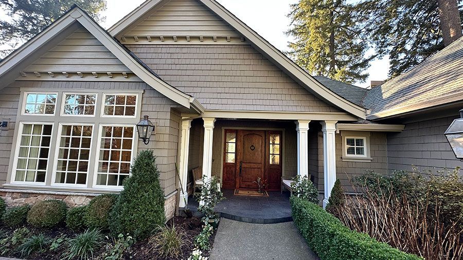 A large house with a large porch and lots of windows