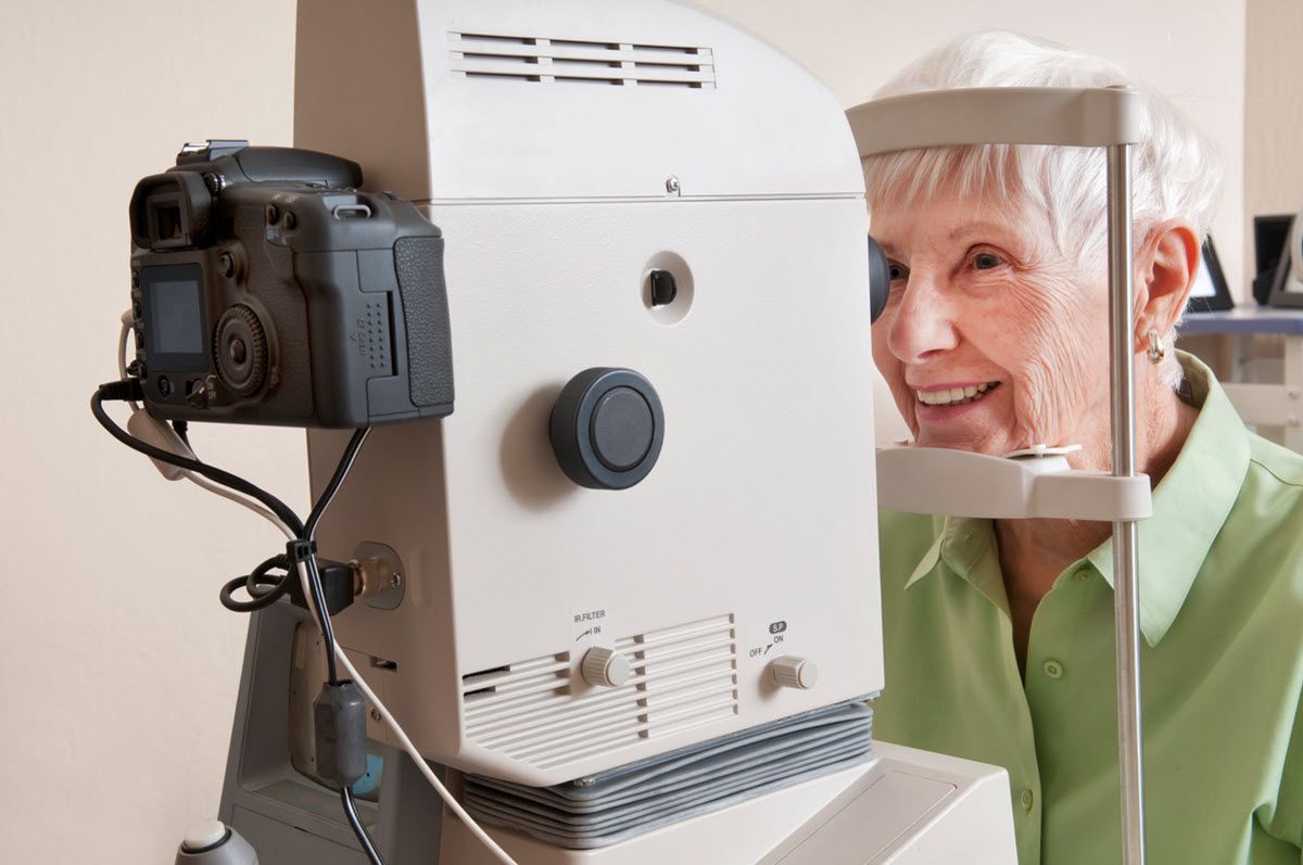 An elderly woman is getting her eyes examined by an ophthalmologist