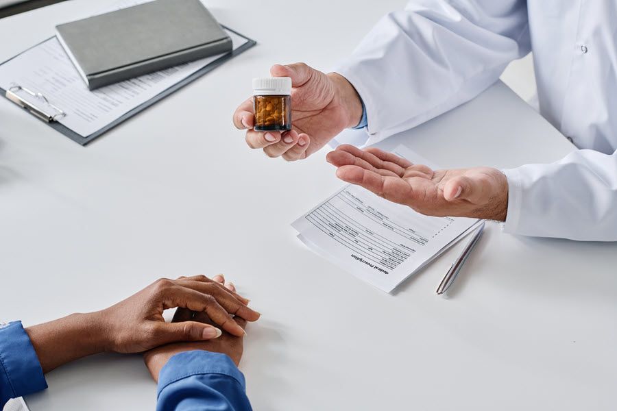 A doctor is giving a patient a bottle of pills.