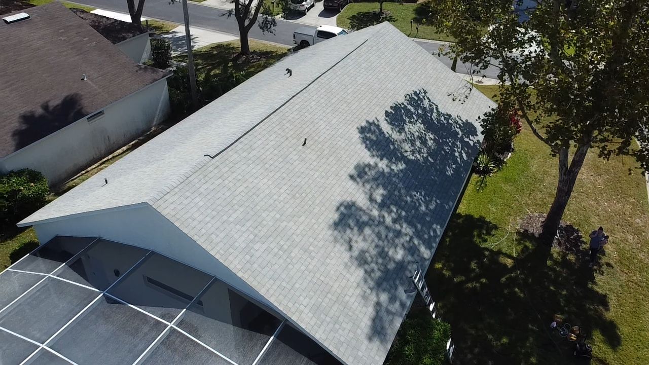 A concrete sidewalk in a residential neighborhood with grass on the side of it.