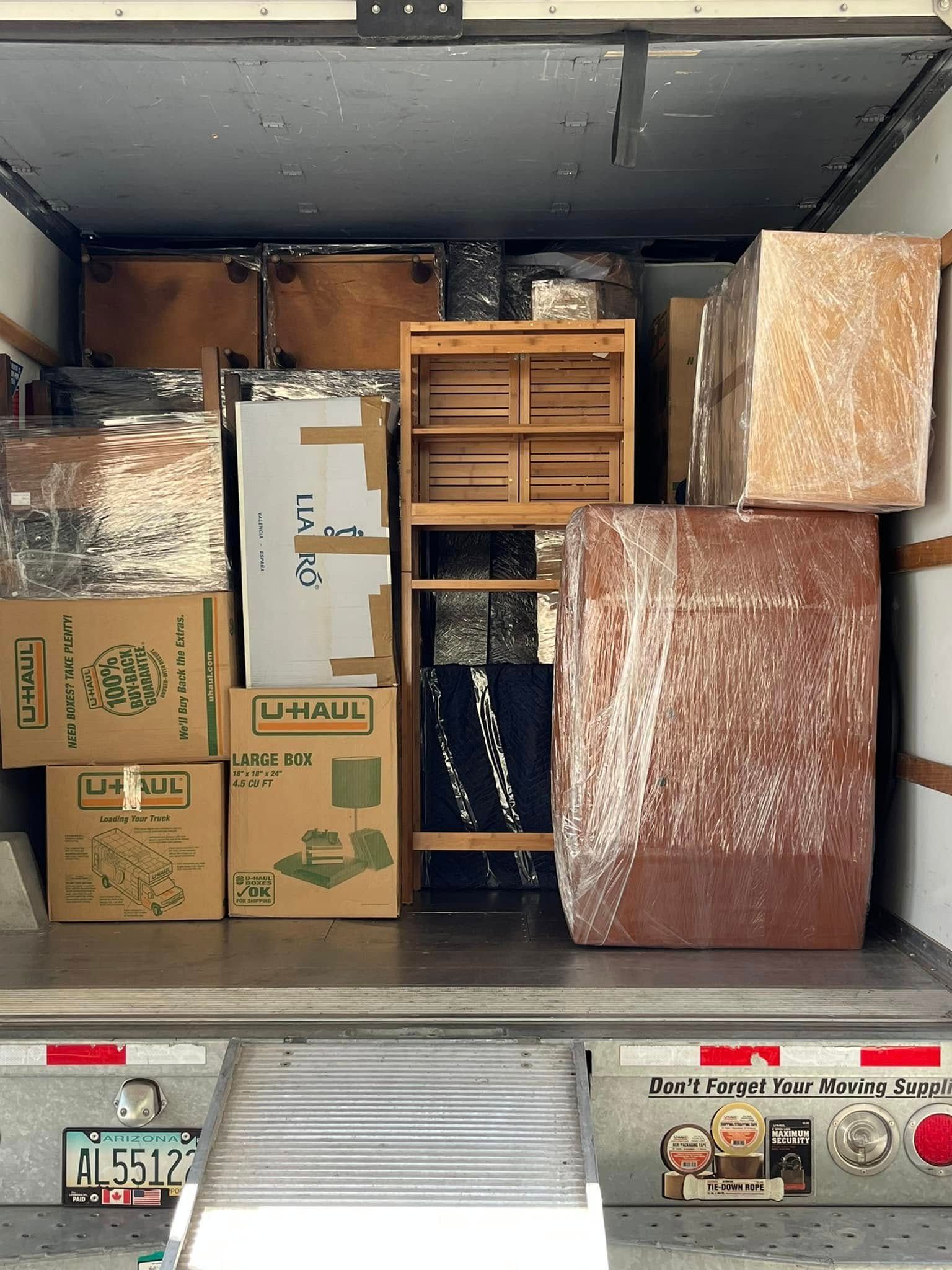 The back of a moving truck filled with boxes and u-haul boxes