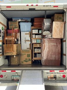 The inside of a moving truck filled with boxes and furniture