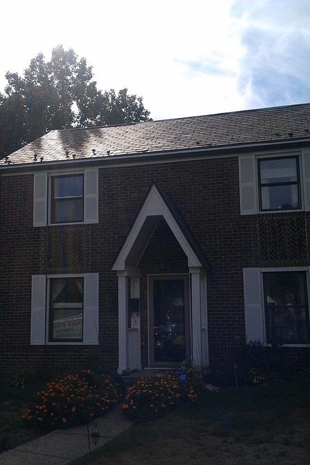A brick house with white shutters on the windows