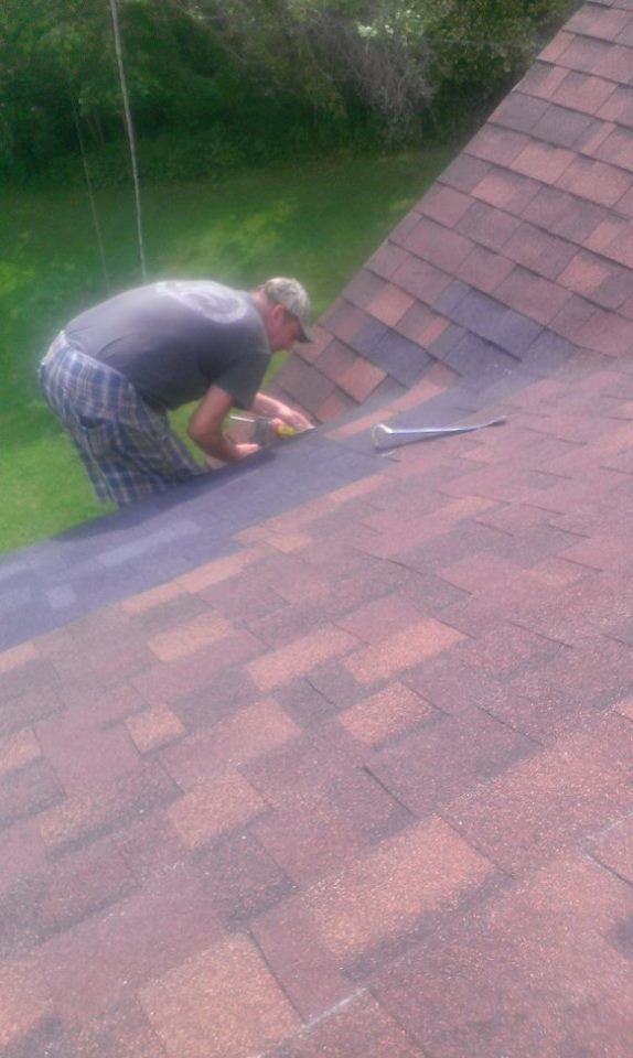 A man is working on the roof of a house.