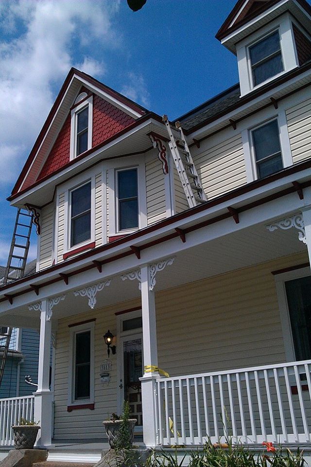 A white house with a red roof and a white porch