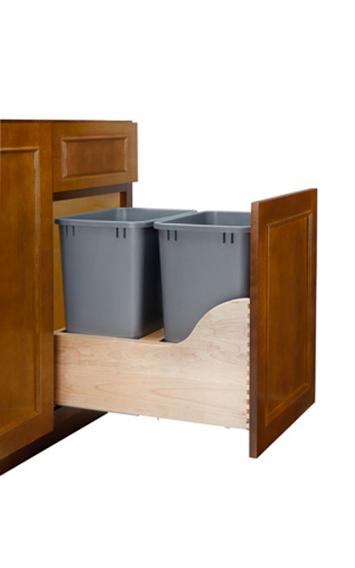 A pull-out kitchen cabinet drawer with two gray plastic trash bins inside.