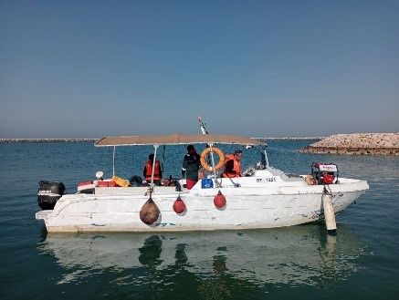 a white boat is floating on top of a body of water .