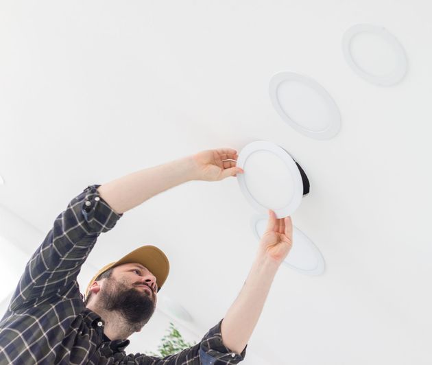 A man in a red hat is working on a wall.