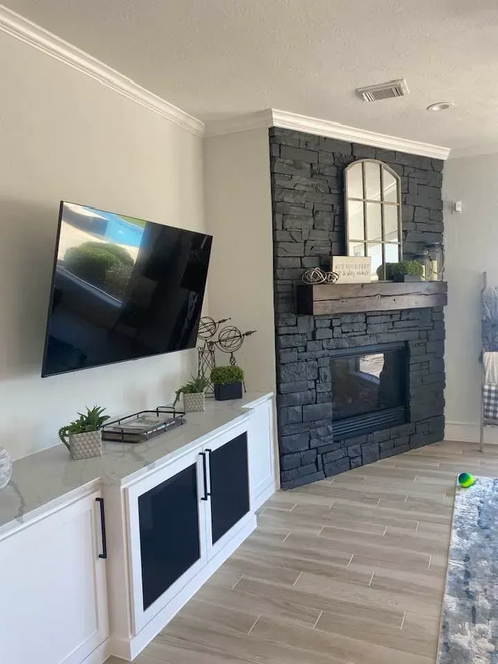 A living room with a fireplace and a flat screen tv.