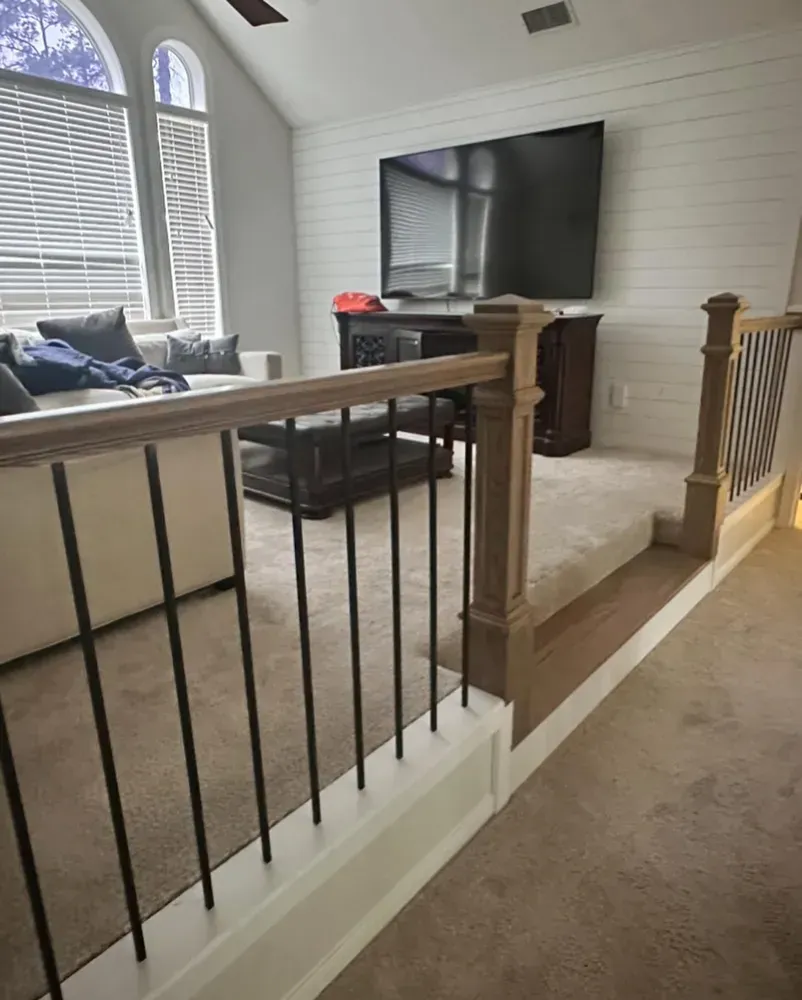 A living room with a couch and a flat screen tv on the wall.