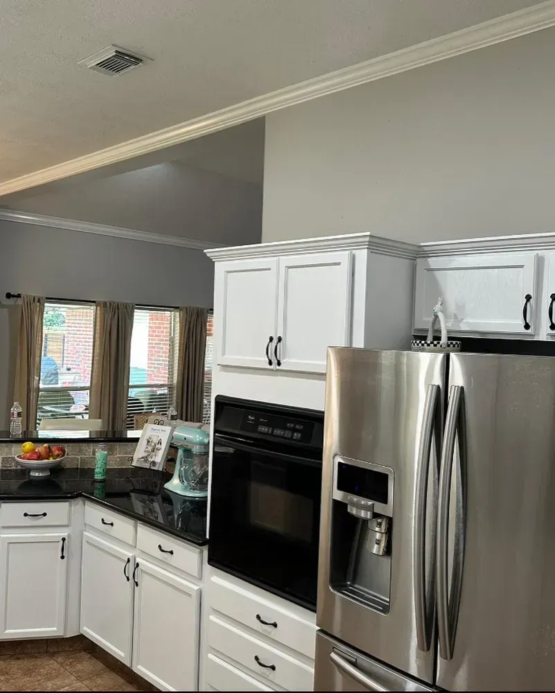 A kitchen with stainless steel appliances and white cabinets