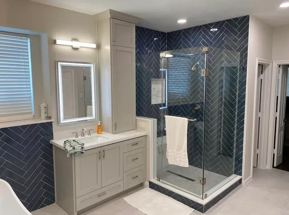 A bathroom with a walk in shower , sink and mirror.