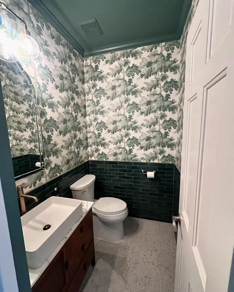 A bathroom with a toilet , sink and mirror.