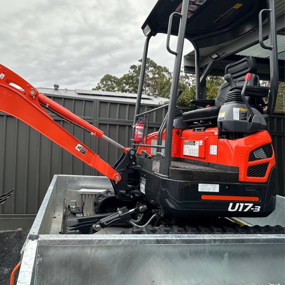 A Red and Black Excavator is Parked in the Back of a Trailer — Garrett's Excavation & Equipment Hire in Sanctuary Point, NSW