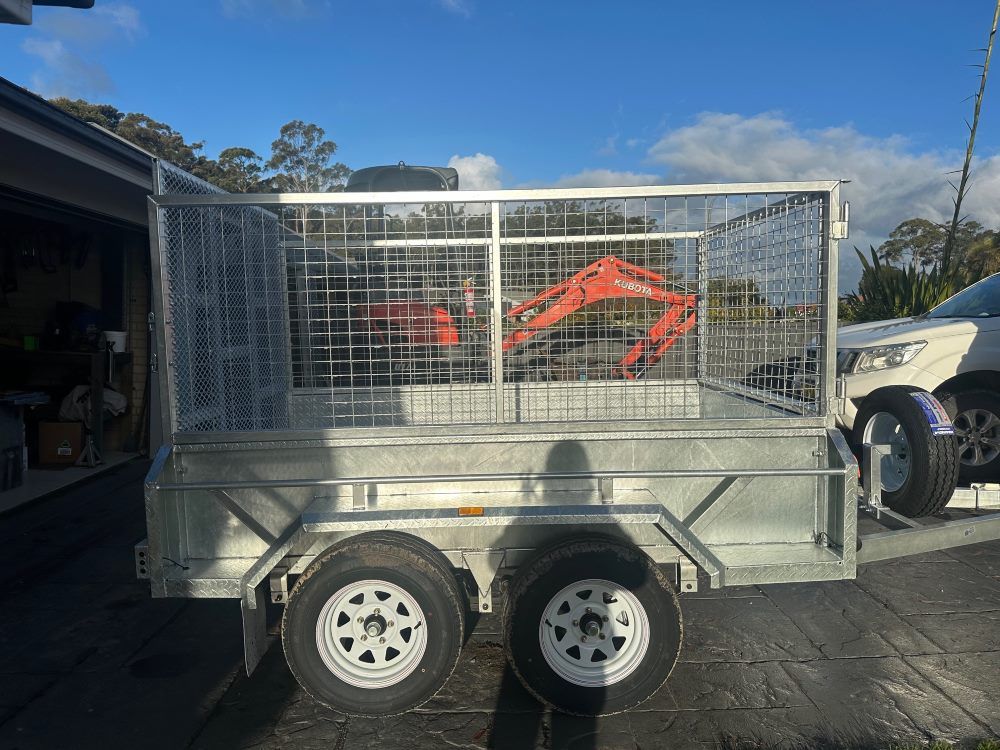 A Trailer With an Excavator in It is Parked in Garage — Garrett's Excavation & Equipment Hire in Sanctuary Point, NSW