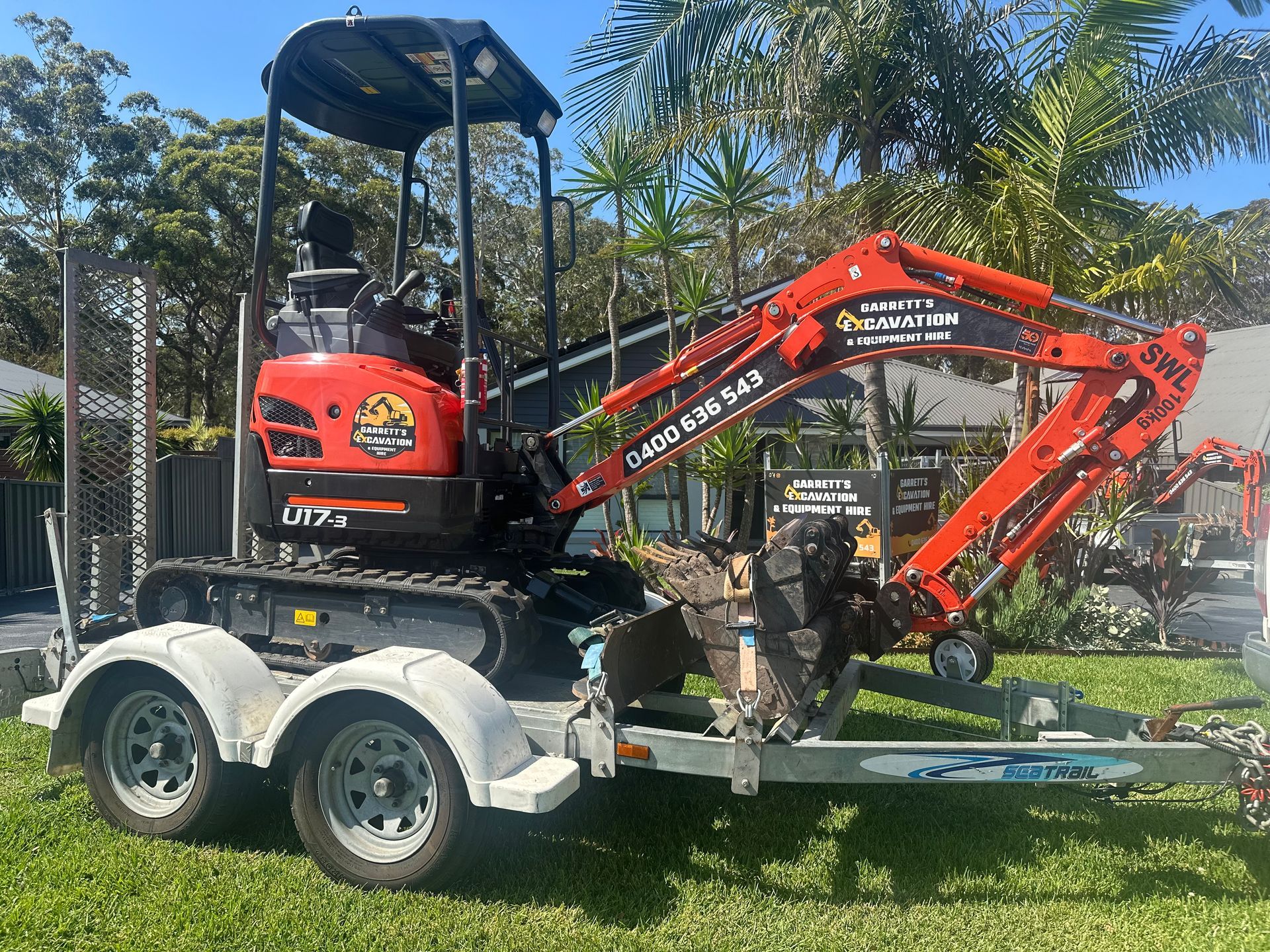 A Small Red Excavator is Parked on a Trailer — Garrett's Excavation & Equipment Hire in Sanctuary Point, NSW