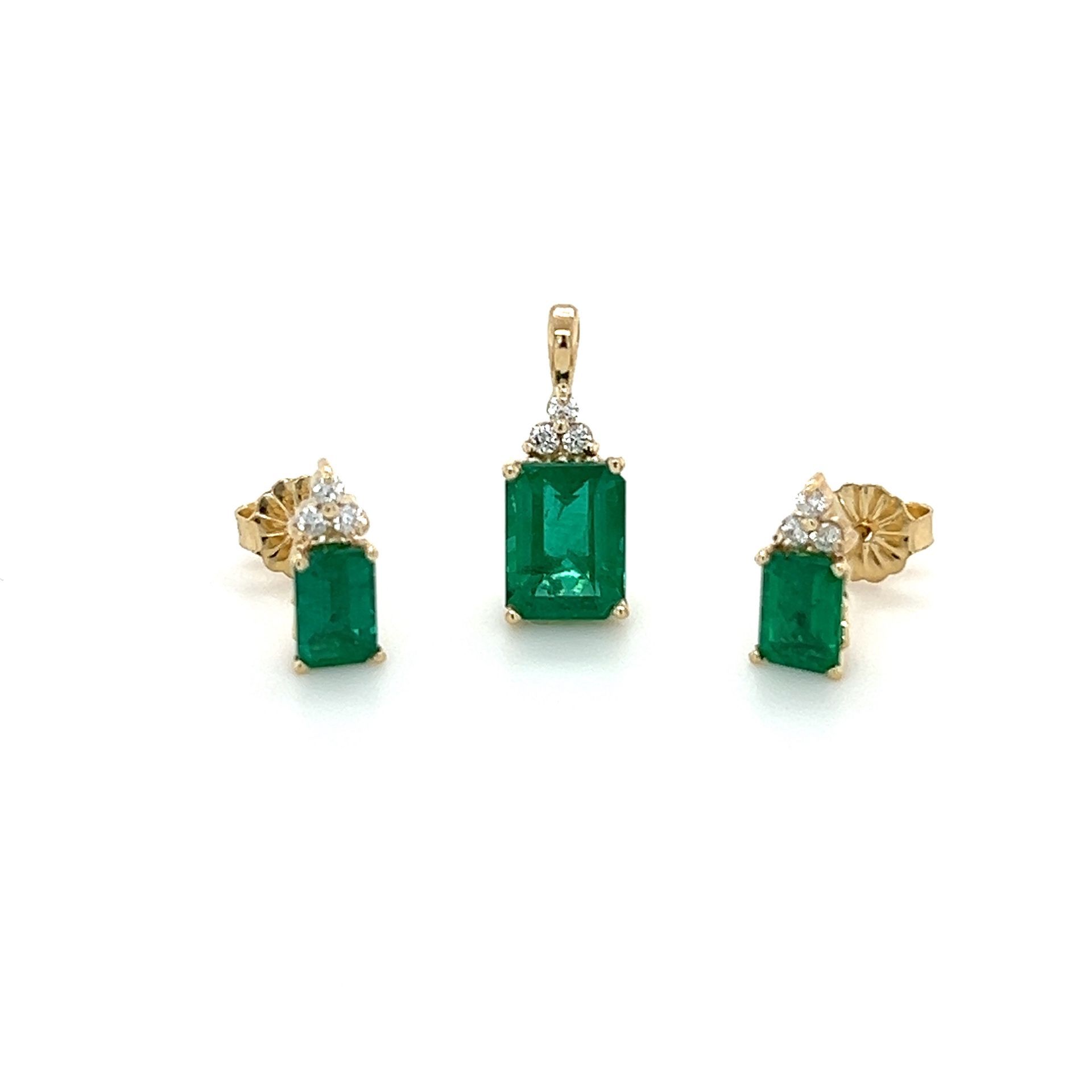 A pendant and earrings set with emeralds and diamonds