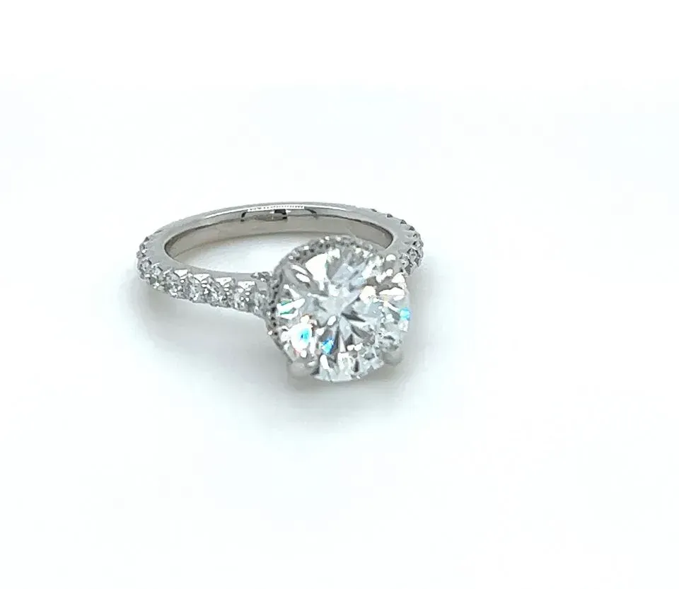 A diamond ring is sitting on a white surface.