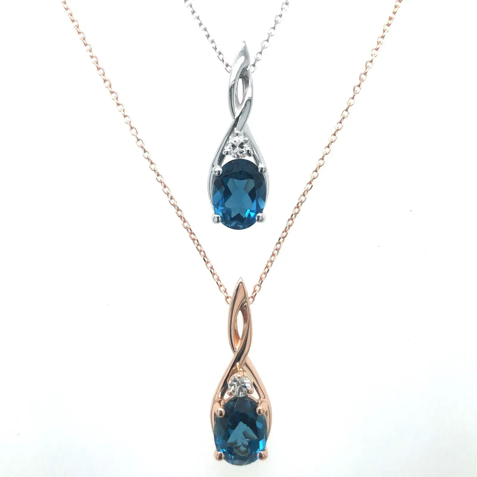 Two necklaces with blue stones and diamonds on a white background