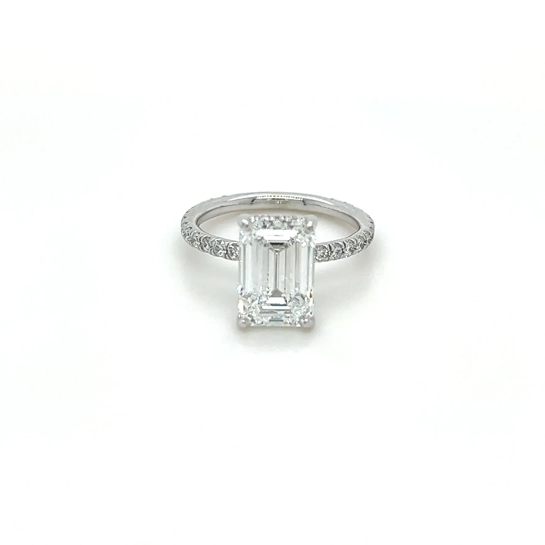 A white gold ring with an emerald cut diamond in the center.
