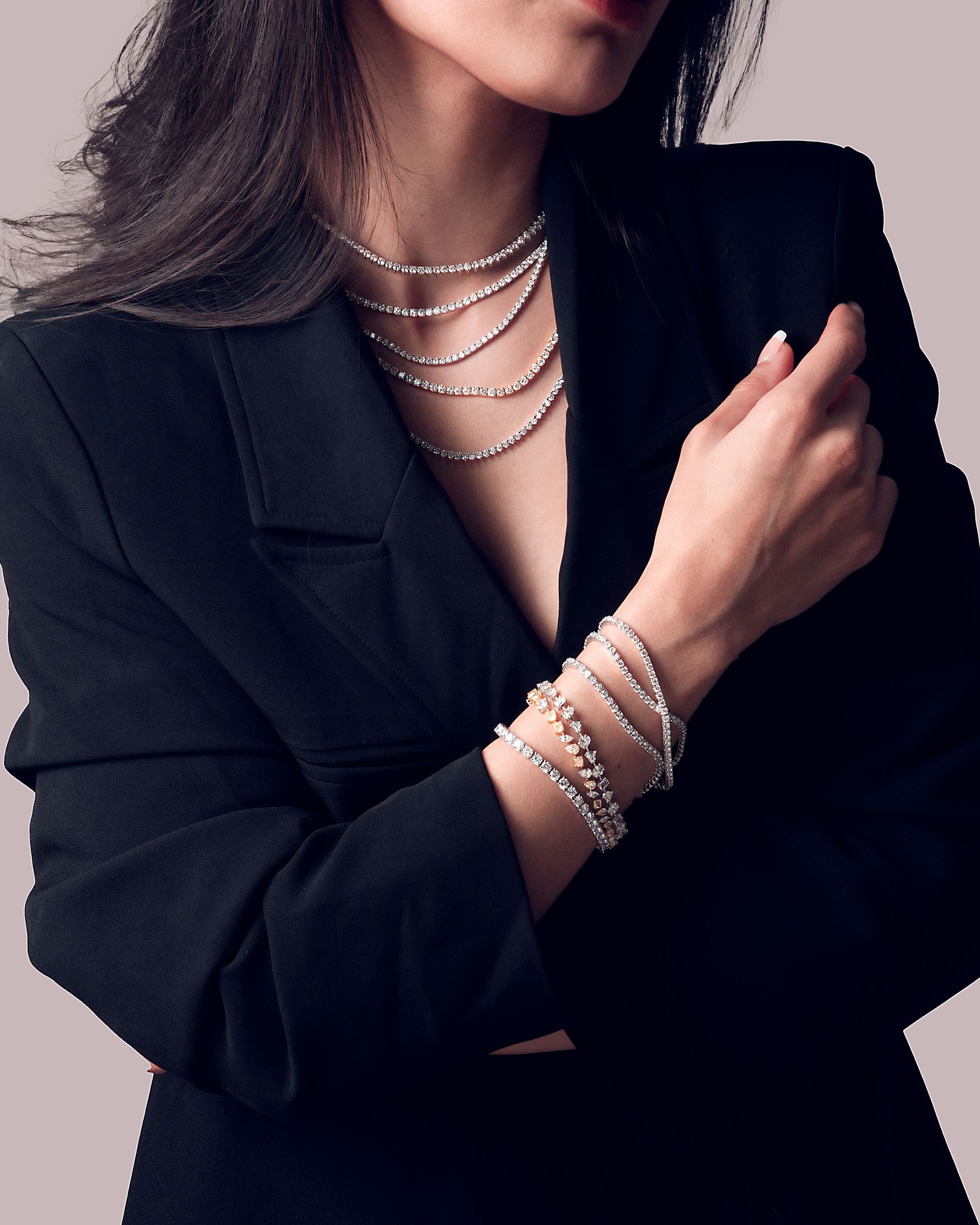 A woman wearing a black jacket and silver bracelets on her wrist