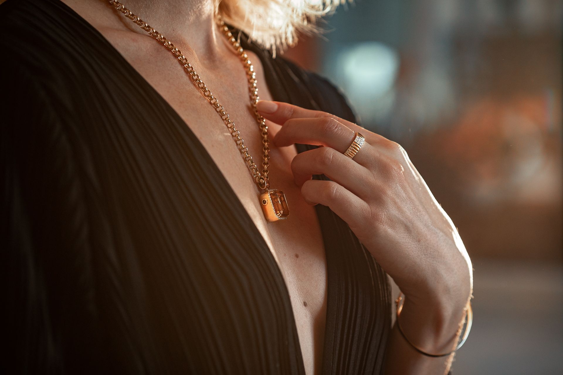 A woman is wearing a necklace and a ring.