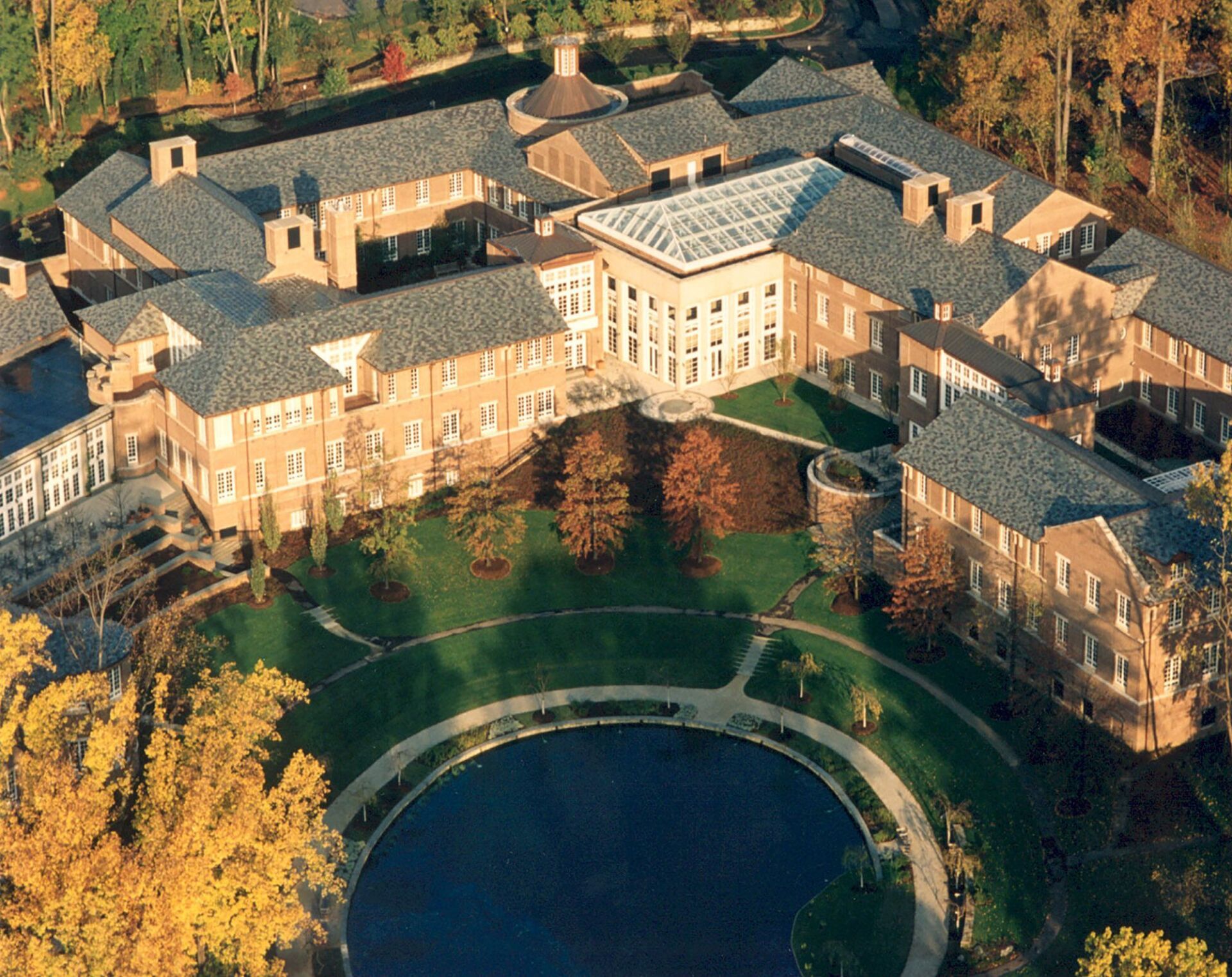 an aerial view of a large building with a pond in the middle
