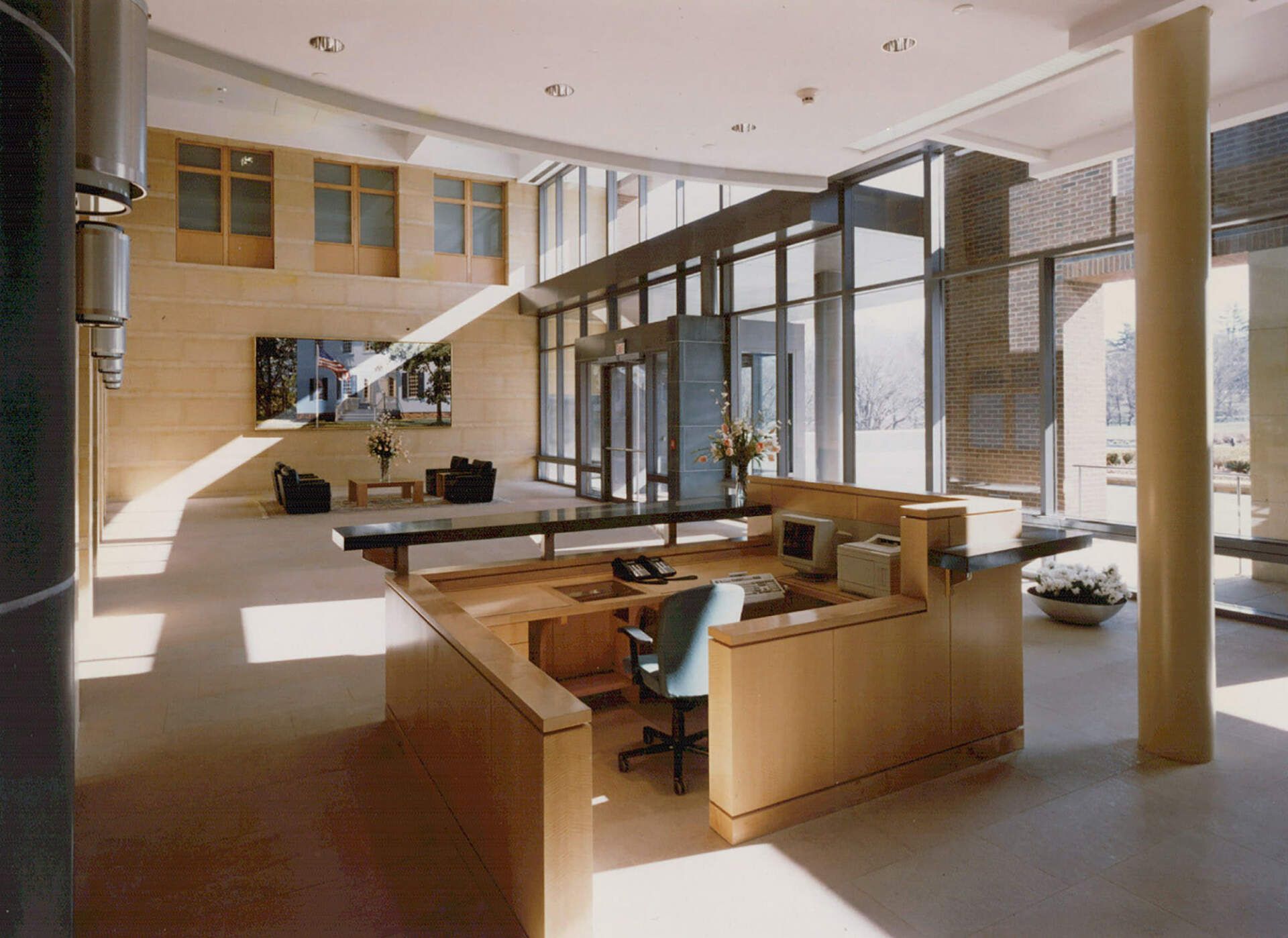 a large room with lots of windows and a desk with a computer on it