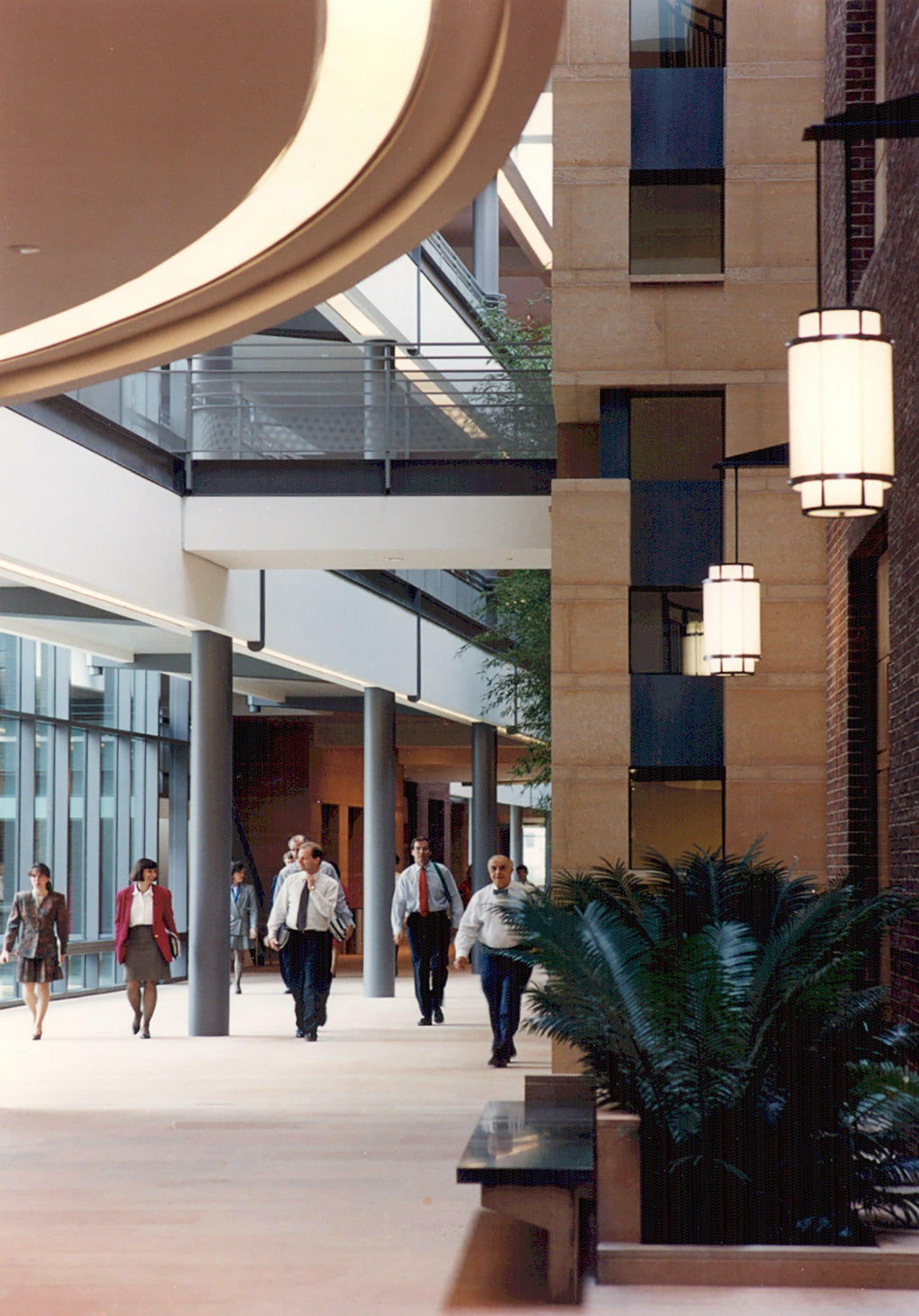 a group of people are walking down a hallway in a building