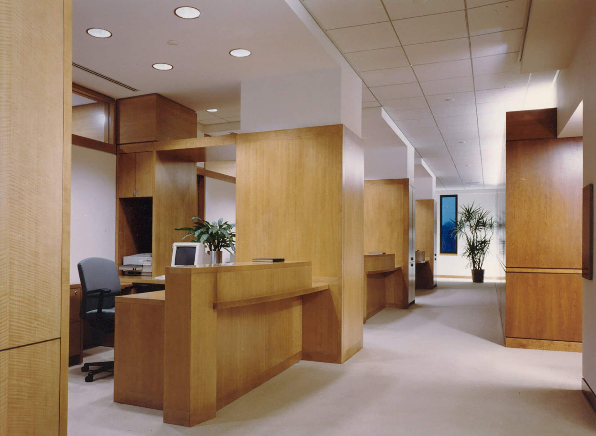 a hallway with wooden walls and a desk with a computer on it