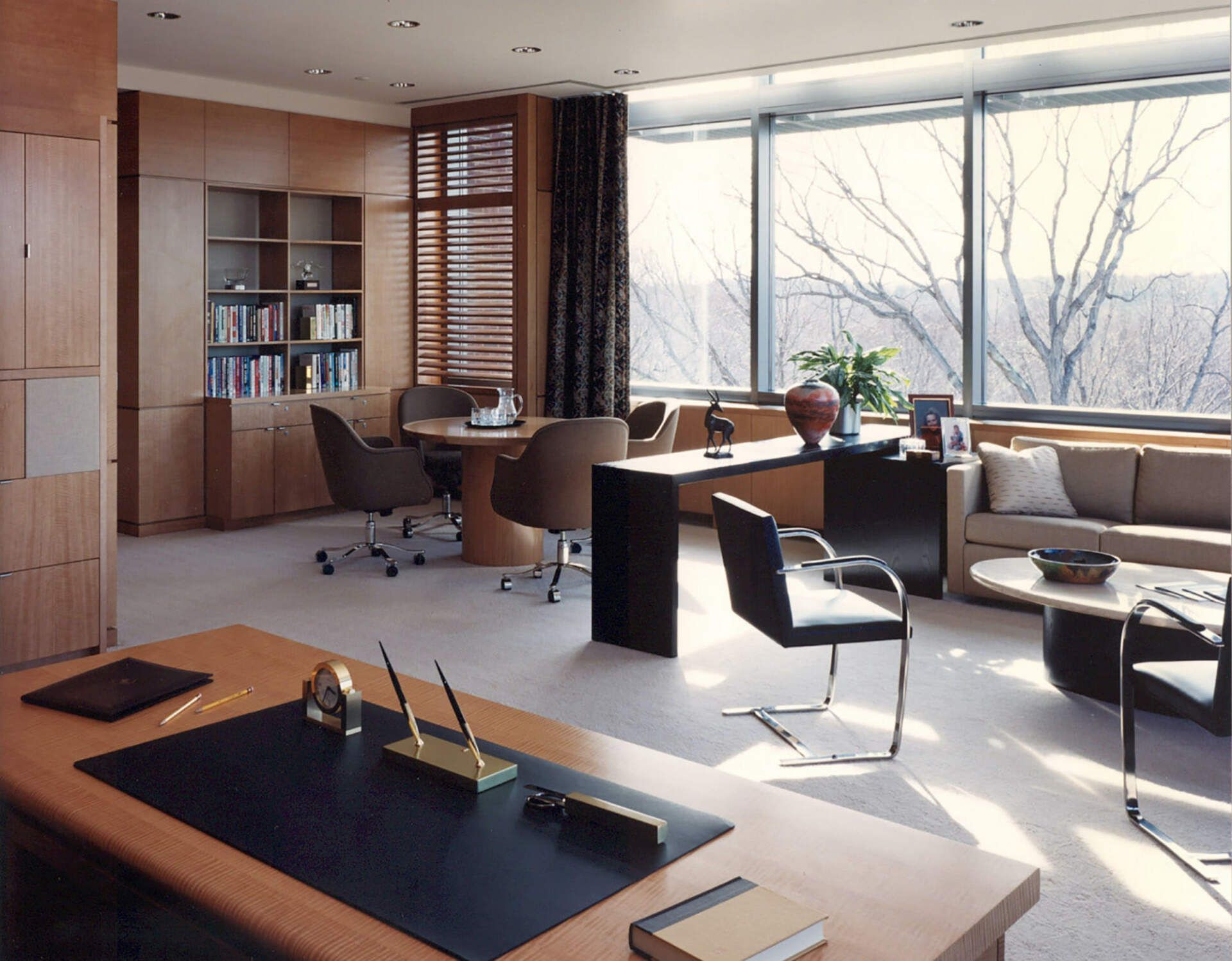 a living room with a desk and chairs and a couch