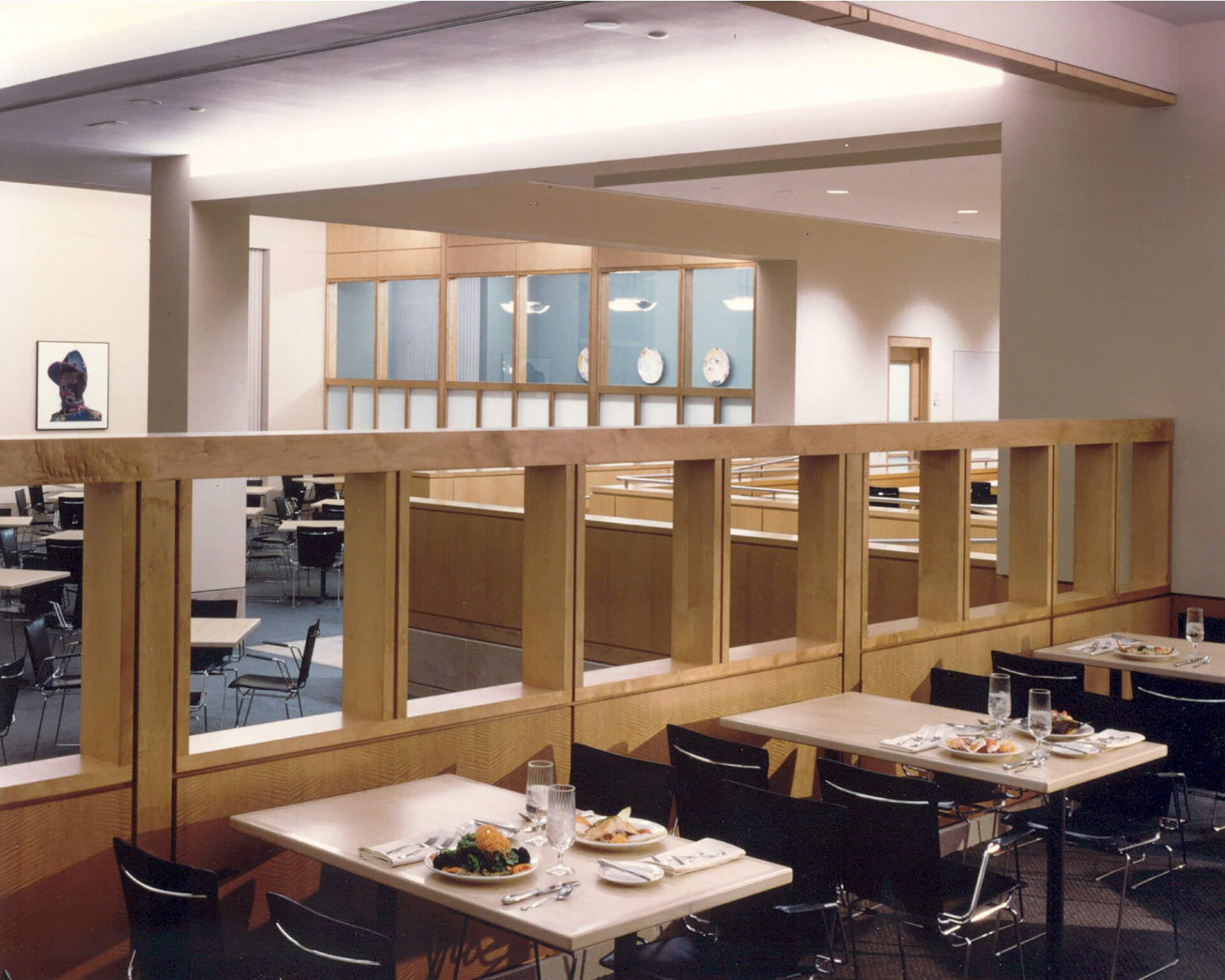 a restaurant with tables and chairs and a wooden divider