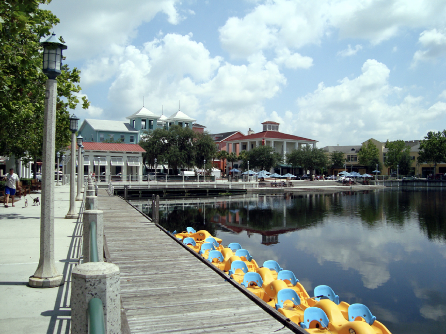 a row of yellow and blue pedal boats on a dock