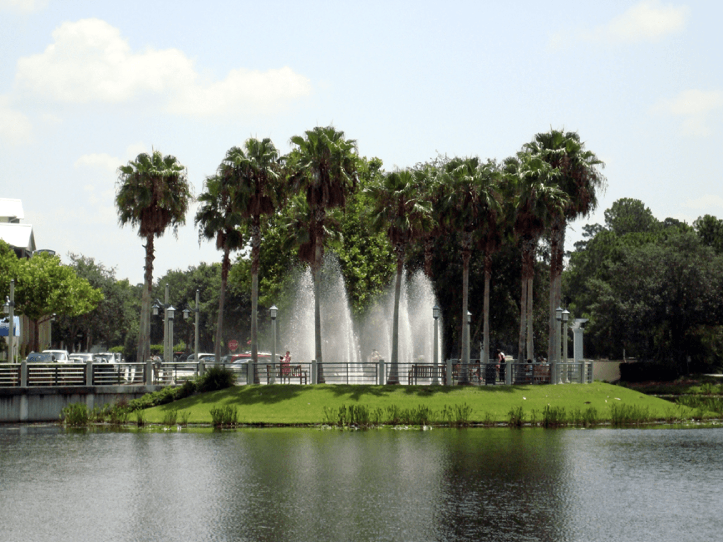 a lake surrounded by palm trees and a fountain