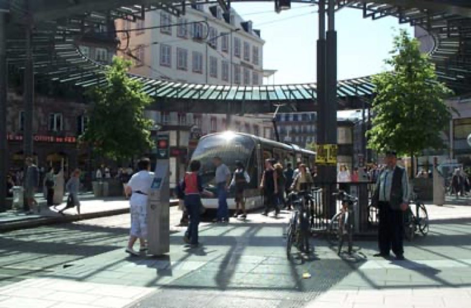 a group of people are waiting for a bus at a bus stop