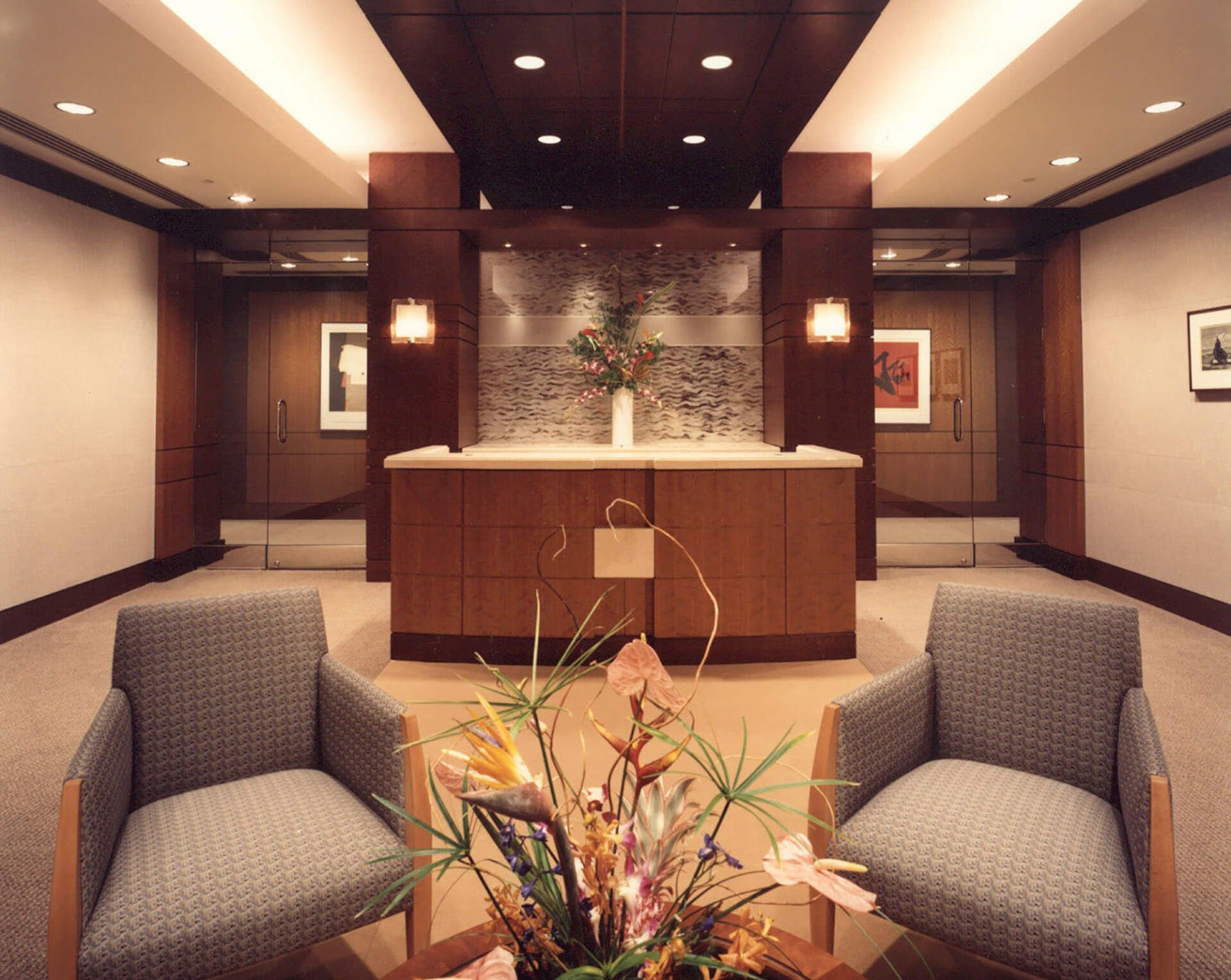 a room with two chairs and a table with flowers in it