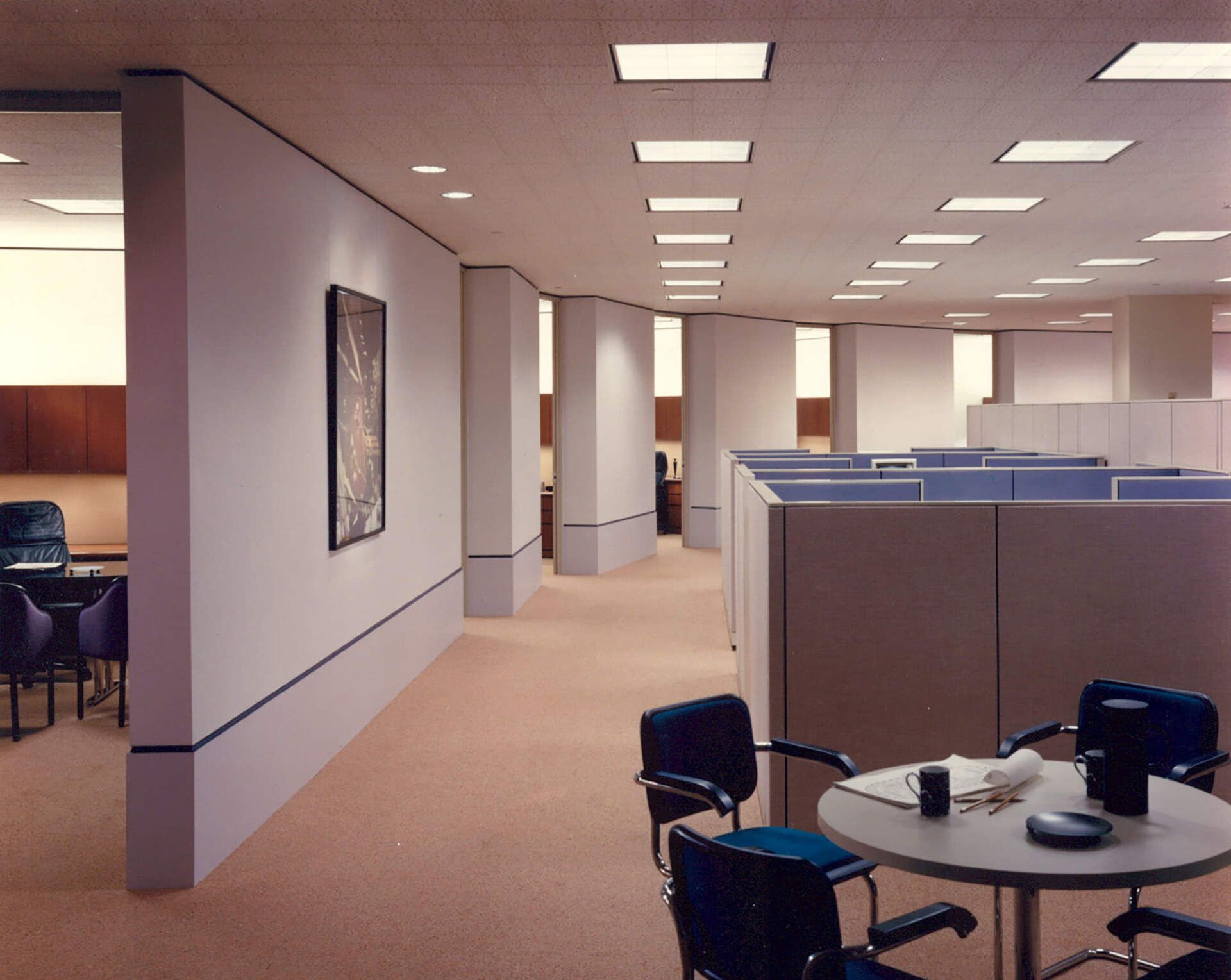 an office with cubicles and a table in the middle