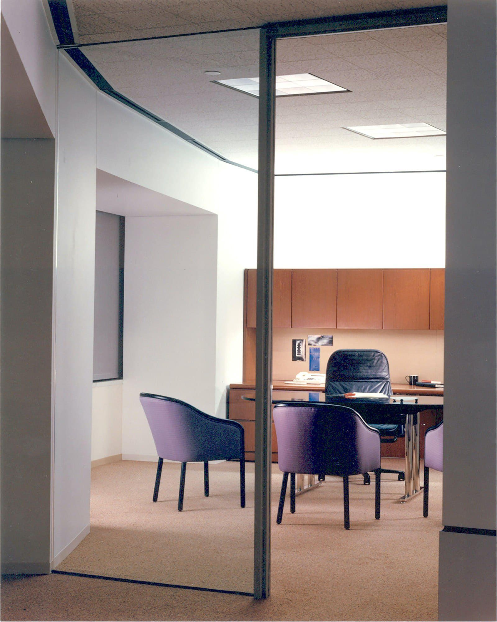 a room with purple chairs and a desk