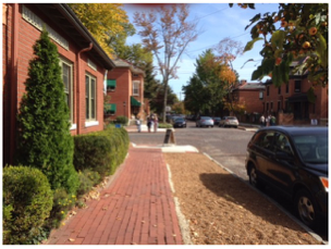 a black car is parked in front of a brick building