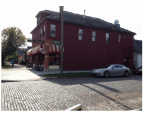 a car is parked in front of a red building