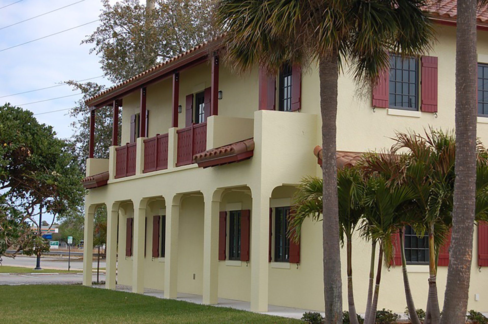 a large yellow building with red shutters on the windows