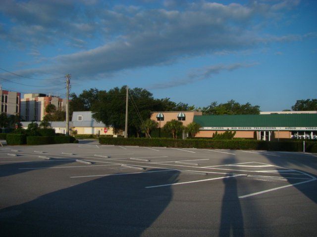 an empty parking lot with a building in the background