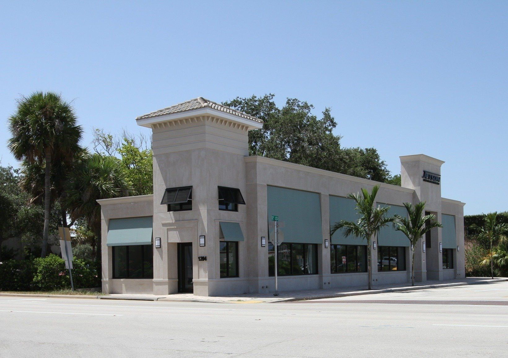 a white building with blue awnings on the windows