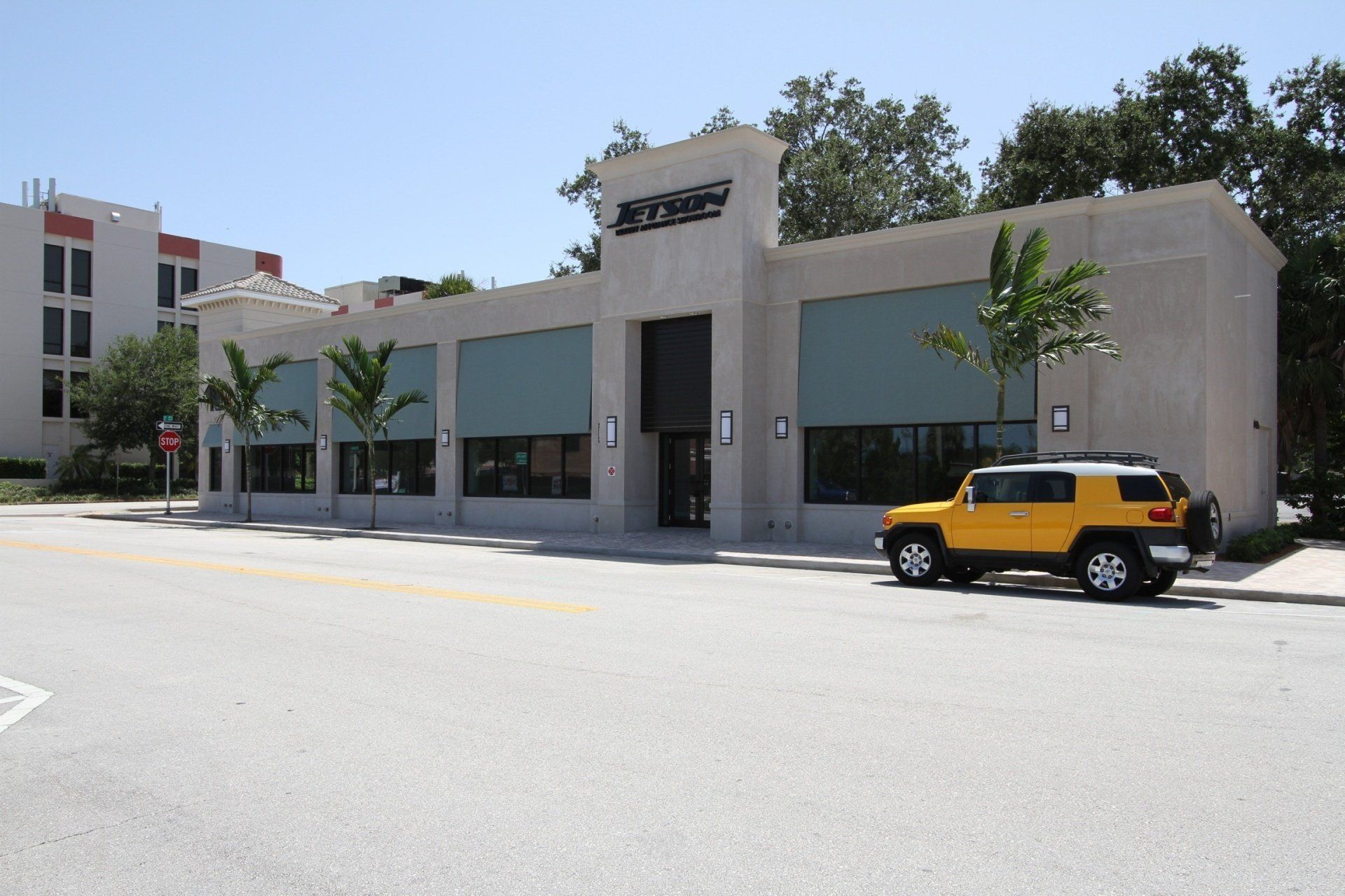 a yellow jeep is parked in front of a building that says pyrex