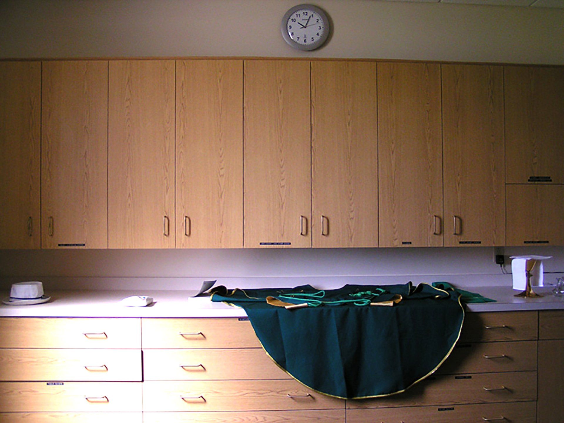 a kitchen with wooden cabinets and a clock on the wall