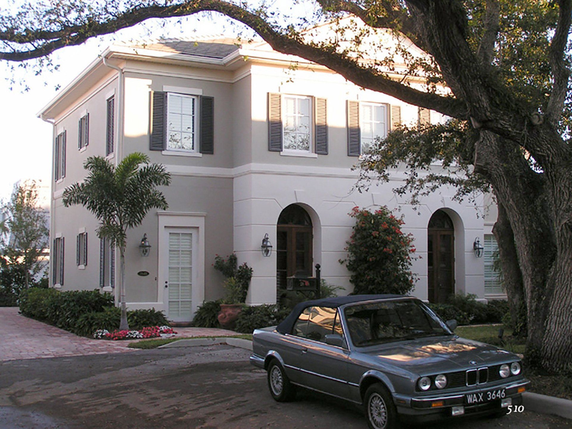 a bmw is parked in front of a white house
